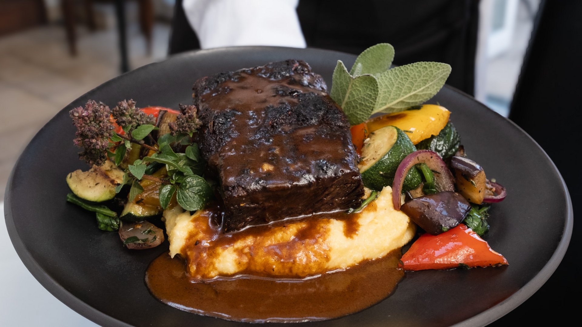 Inn & Restaurant in Parsberg serving regional cuisine Braised meat with vegetables and purée served on a black plate