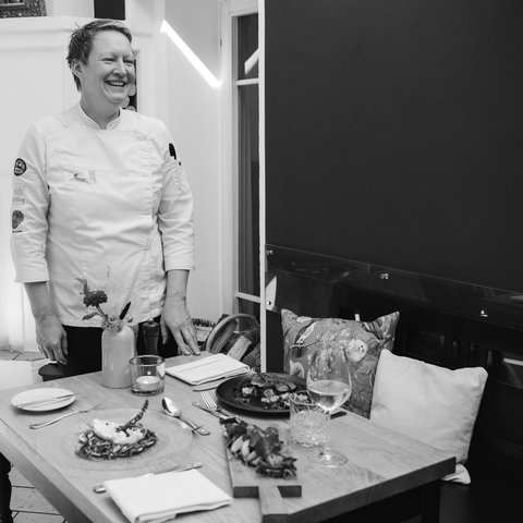 Inn & Restaurant in Parsberg serving regional cuisine Smiling chef beside a set table with plated dishes