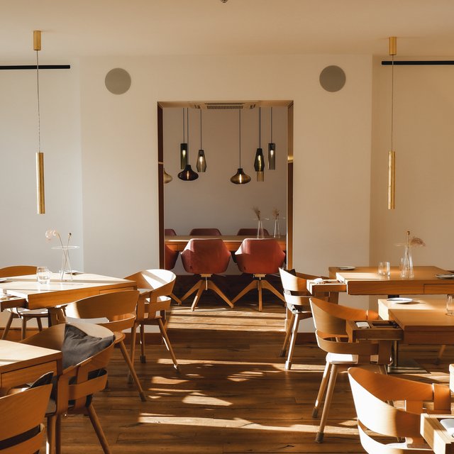 Home Modernes Restaurant mit Holzstühlen und warmen Hängelampen