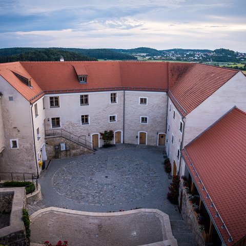 Hotels in Regensburg and its surroundings: culturally rich! Courtyard of a historic building with red tile roofs and surrounding landscape view