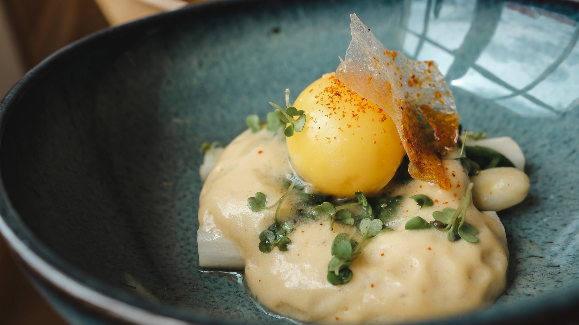 Restaurant in Parsberg: Enjoy gourmet Gourmet dish with sauce and edible leaves in a blue bowl