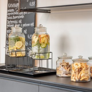 Beer garden love Glass dispensers with fruit water and three jars with snacks on the counter