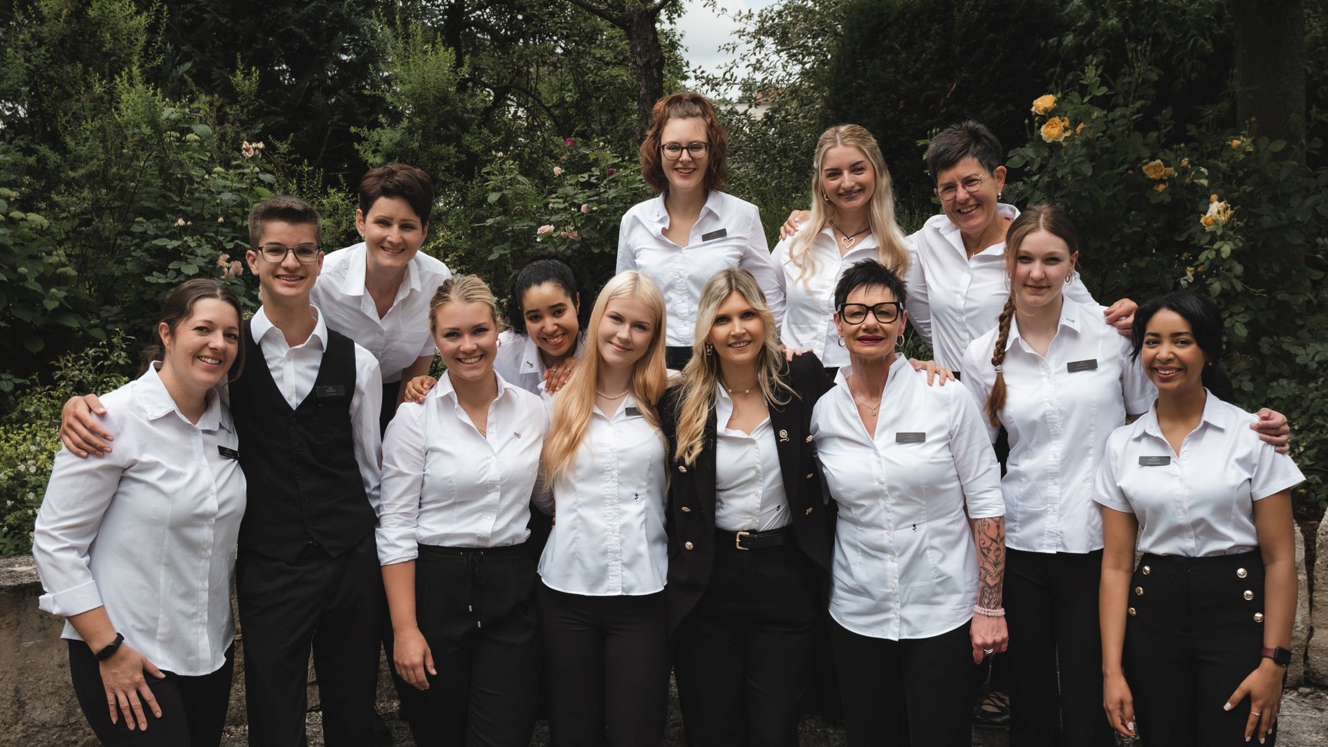 Gasthof & Restaurant in Parsberg mit regionaler Küche Gruppenfoto von Mitarbeitern in weißen Hemden vor grüner Kulisse