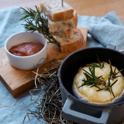 Gasthof & Restaurant in Parsberg mit regionaler Küche Geschmolzener Käse mit Rosmarin in einem Topf, serviert mit Brot und Sauce