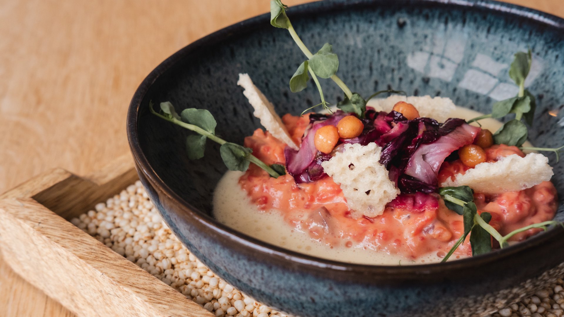 Home Gourmetgericht mit Creme, Crostini und frischen Kräutern im blauen Teller