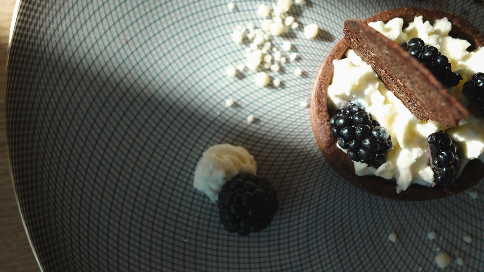Fine Dining & Gourmet Cuisine in the Upper Palatinate Tart topped with cream, dark berries and a piece of chocolate on a plate