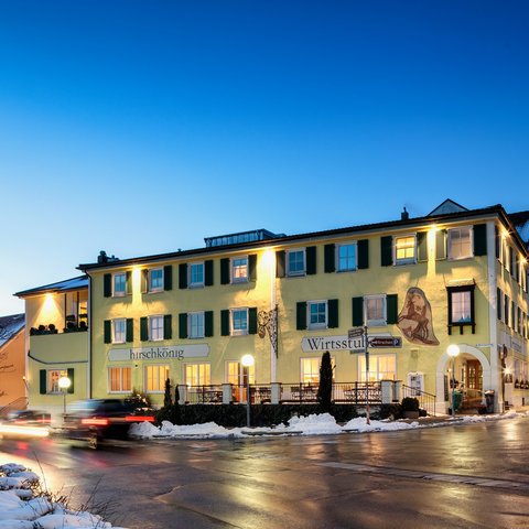 Beer garden love Lit yellow building at dusk with snow and cars on the street