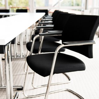 Restaurant in Parsberg: Enjoy gourmet Black office chairs beside white conference table in bright room