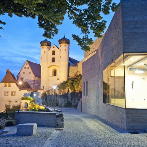 Hotels in Regensburg and its surroundings: culturally rich! Historic castle complex at dusk with illuminated buildings