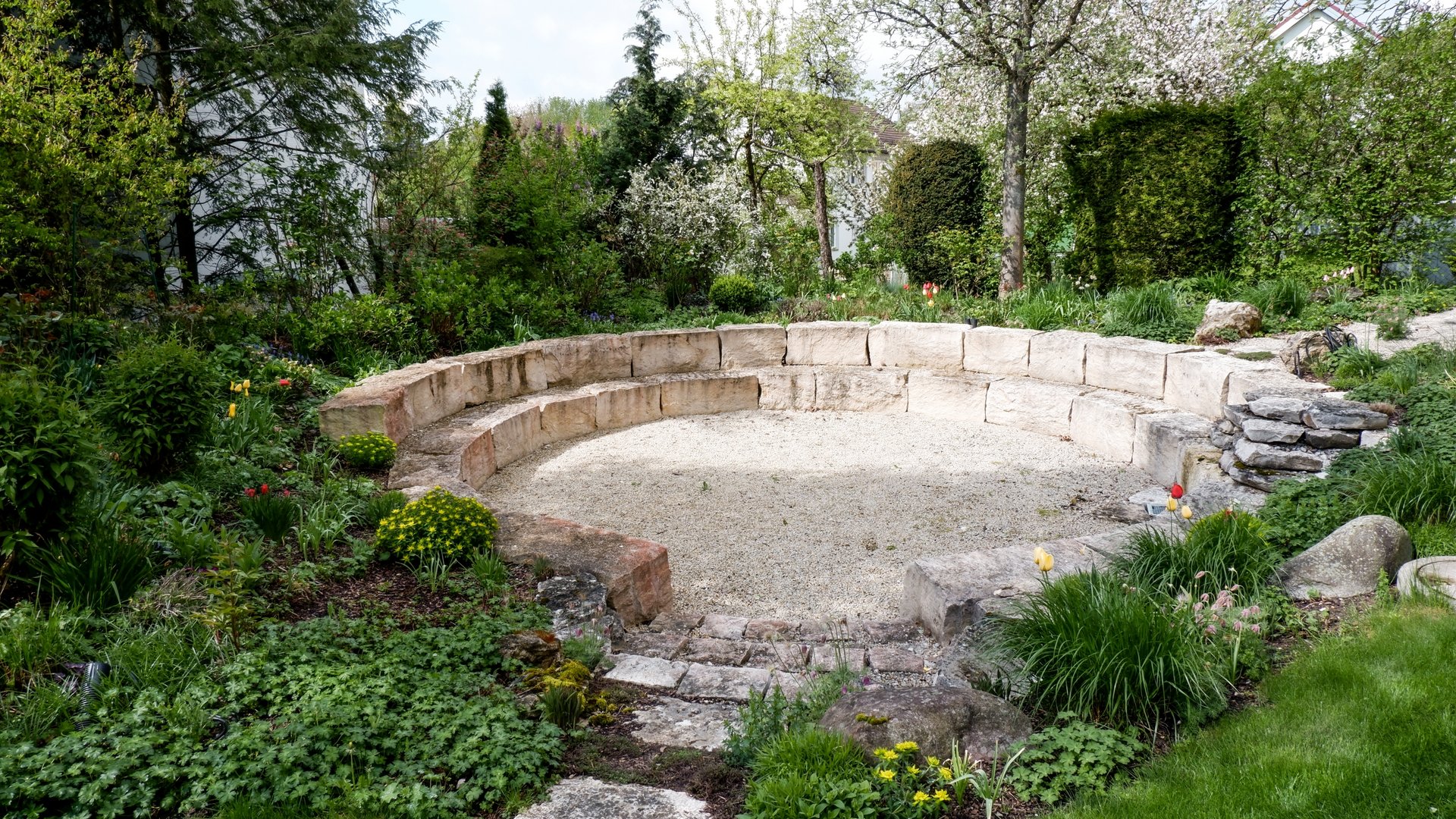 Services and rates for conferences and celebrations Stone circular bench in garden surrounded by flowers and shrubs