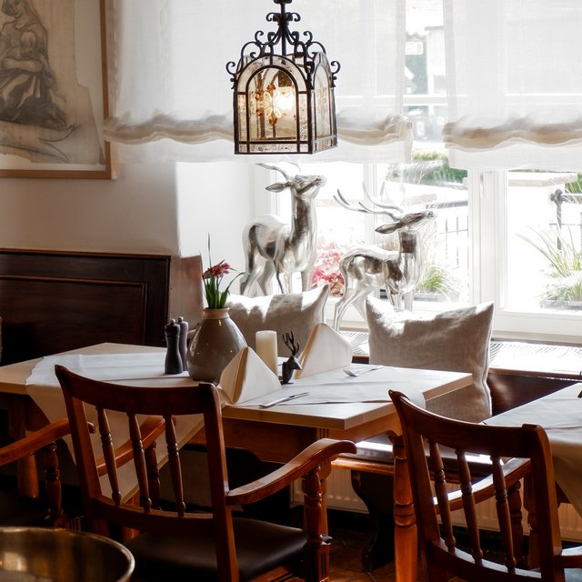 Home Gemütliches Restaurant mit Holzmöbeln, Fensterdeko und gedeckten Tischen