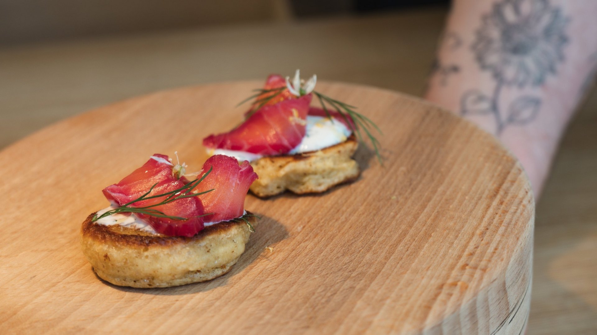 Restaurant in Parsberg: Enjoy gourmet Two canapés with salmon and herbs on a wooden board