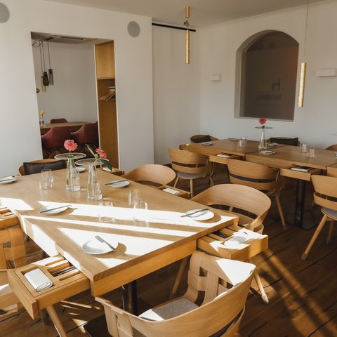 Restaurant in Parsberg: Enjoy gourmet Bright restaurant with wooden tables and chairs set with plates and glasses