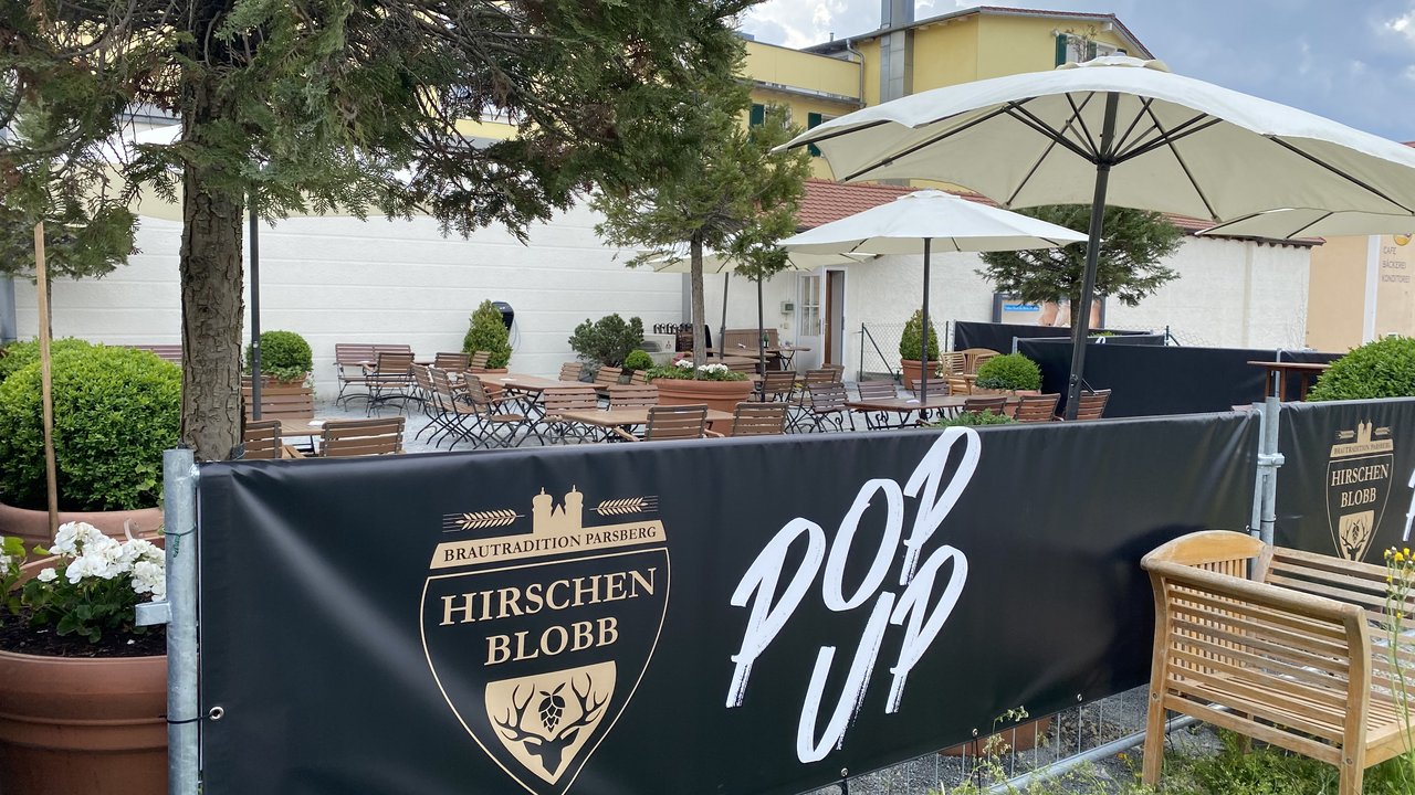 Beer garden love Outdoor area of a pop-up with tables, chairs, and large umbrellas