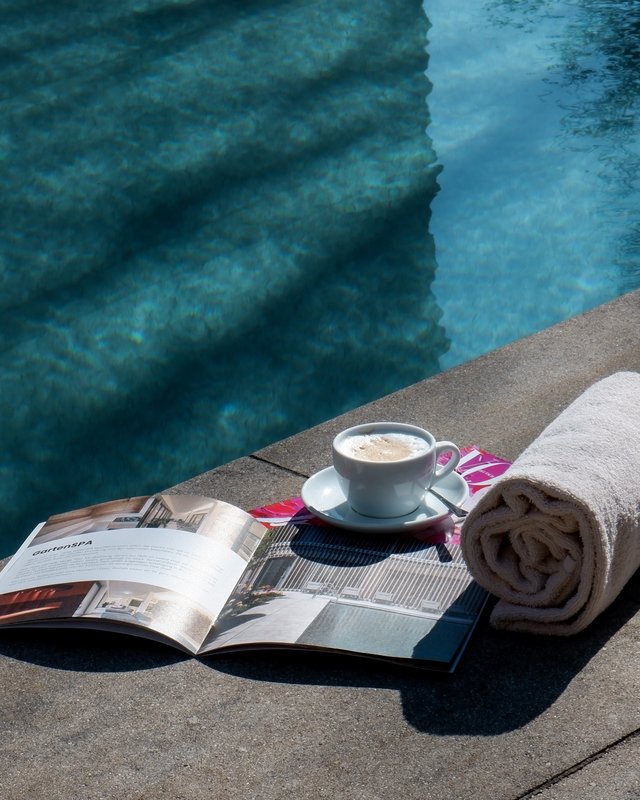 Wellnesshotel Oberpfalz | Romantik Hotel Hirschen Parsberg Kaffeetasse, Handtücher und Magazin am Poolrand