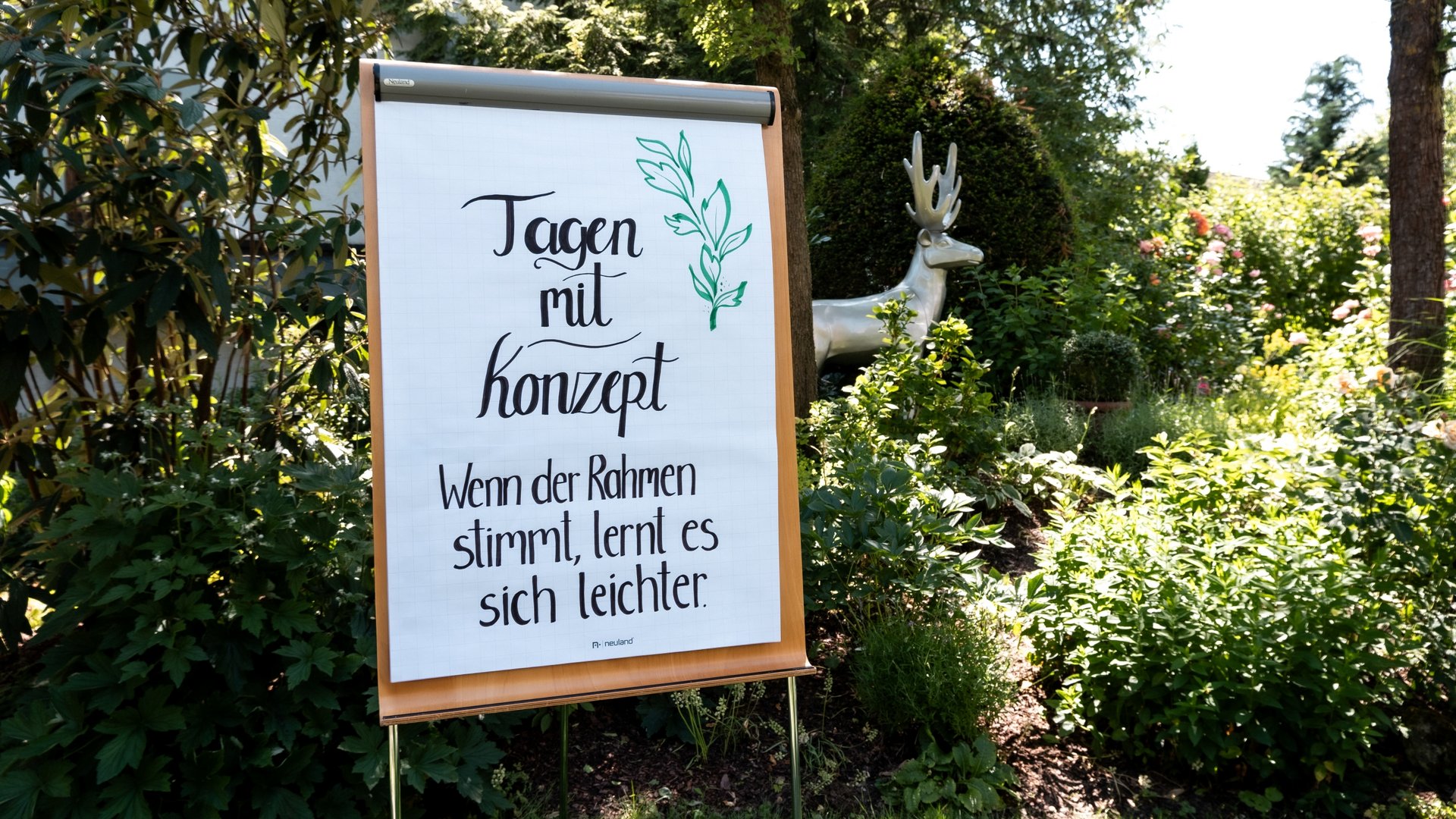 Services and rates for conferences and celebrations Flipchart with handwritten quote in a garden with a sculpture