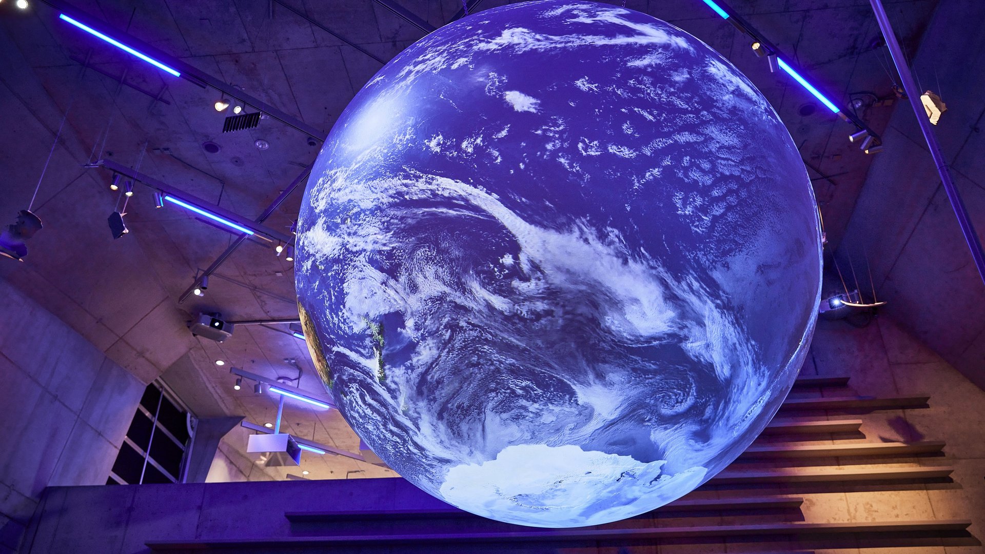 Hotels in Regensburg and its surroundings: culturally rich! Large glowing Earth installation in modern room with blue lighting