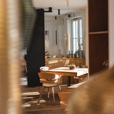 Restaurant in Parsberg: Enjoy gourmet Bright modern room with wooden tables and chairs.