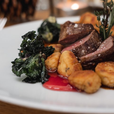 Gasthof & Restaurant in Parsberg mit regionaler Küche Gebackene Kartoffelgnocchi mit Rindersteak und grünem Gemüse auf weißem Teller