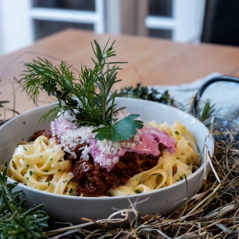 Gasthof & Restaurant in Parsberg mit regionaler Küche Nudeln mit Bolognese, Käse und Kräutern serviert in einer Schale auf einem Tisch