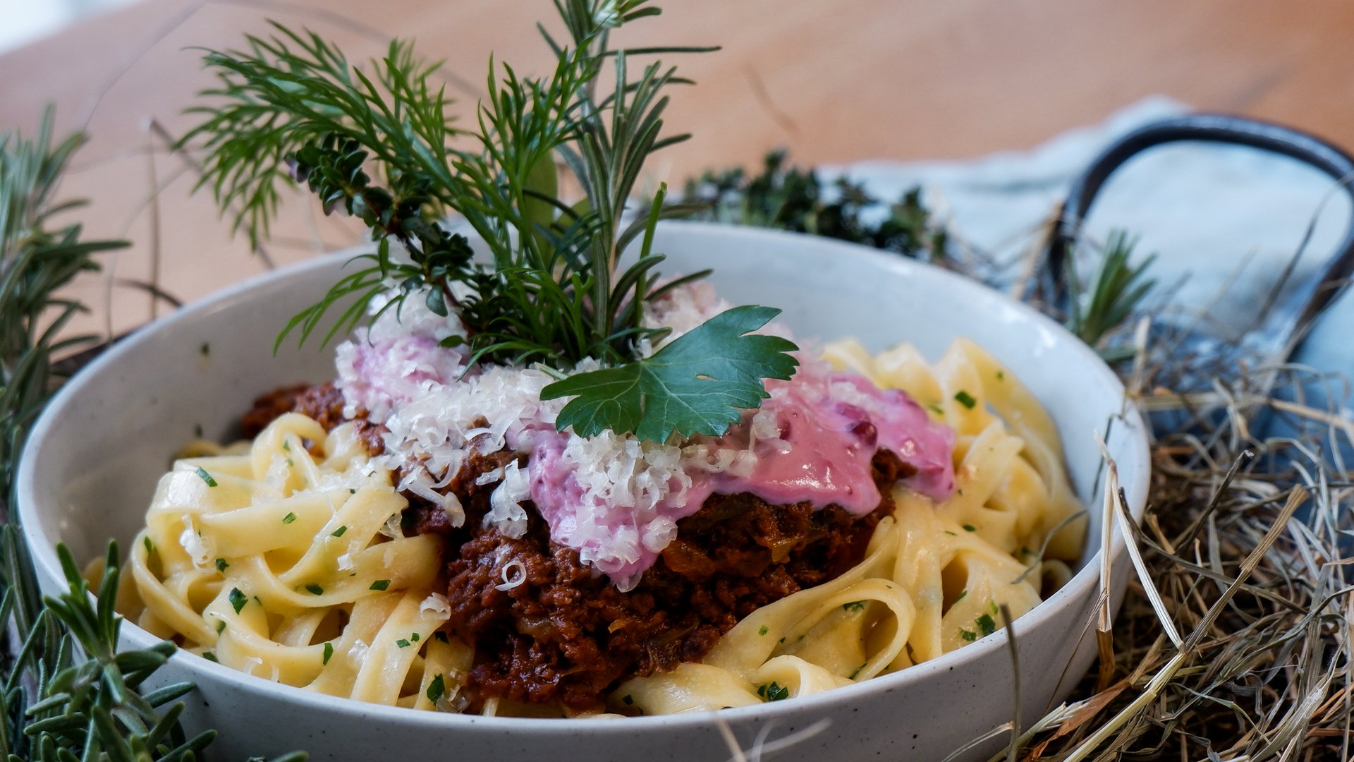 Gasthof & Restaurant in Parsberg mit regionaler Küche Nudeln mit Bolognese, Käse und Kräutern serviert in einer Schale auf einem Tisch