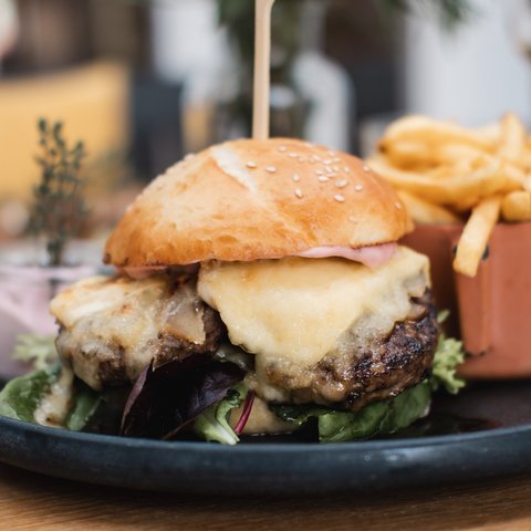 Gasthof & Restaurant in Parsberg mit regionaler Küche Cheeseburger mit Salat und Pommes auf schwarzem Teller