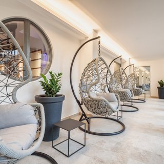 Restaurant in Parsberg: Enjoy gourmet Modern hanging chairs with gray cushions in a bright room with plants