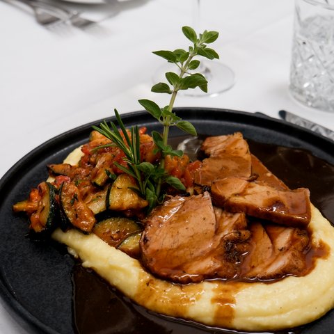 Gasthof & Restaurant in Parsberg mit regionaler Küche Schweinebraten mit Kartoffelpüree, Gemüse und dunkler Sauce garniert mit Kräutern