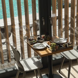 Home Kleiner Tisch mit Essen und zwei Stühlen neben Fenster mit Poolblick