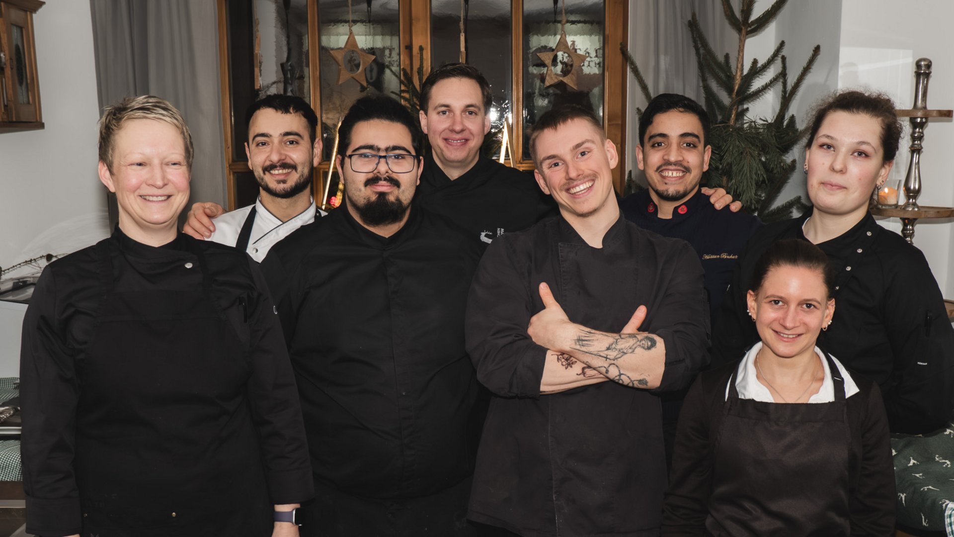 Gasthof & Restaurant in Parsberg mit regionaler Küche Gruppenfoto von acht lächelnden Küchenmitarbeitern in schwarzer Arbeitskleidung