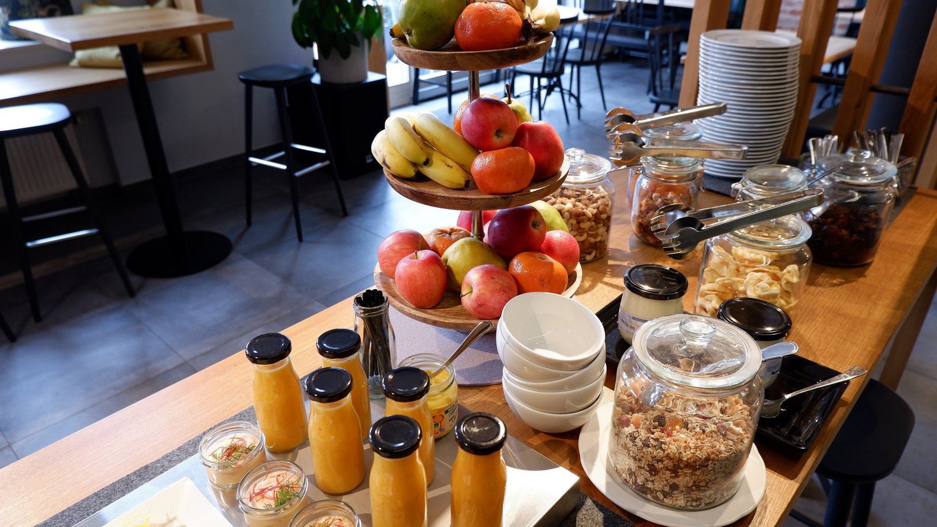 Services and rates for conferences and celebrations Breakfast buffet with fruit, jars of cereal, and juices on a wooden table