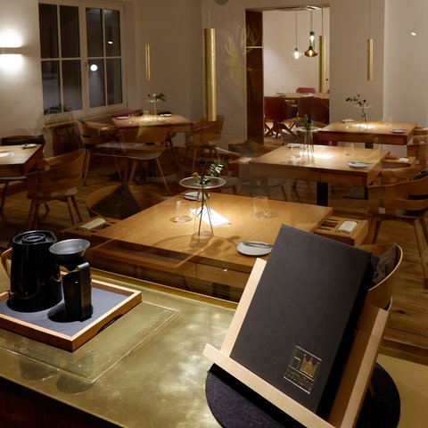 Restaurant in Parsberg: Enjoy gourmet Modern restaurant with wooden furniture and set tables under soft lighting