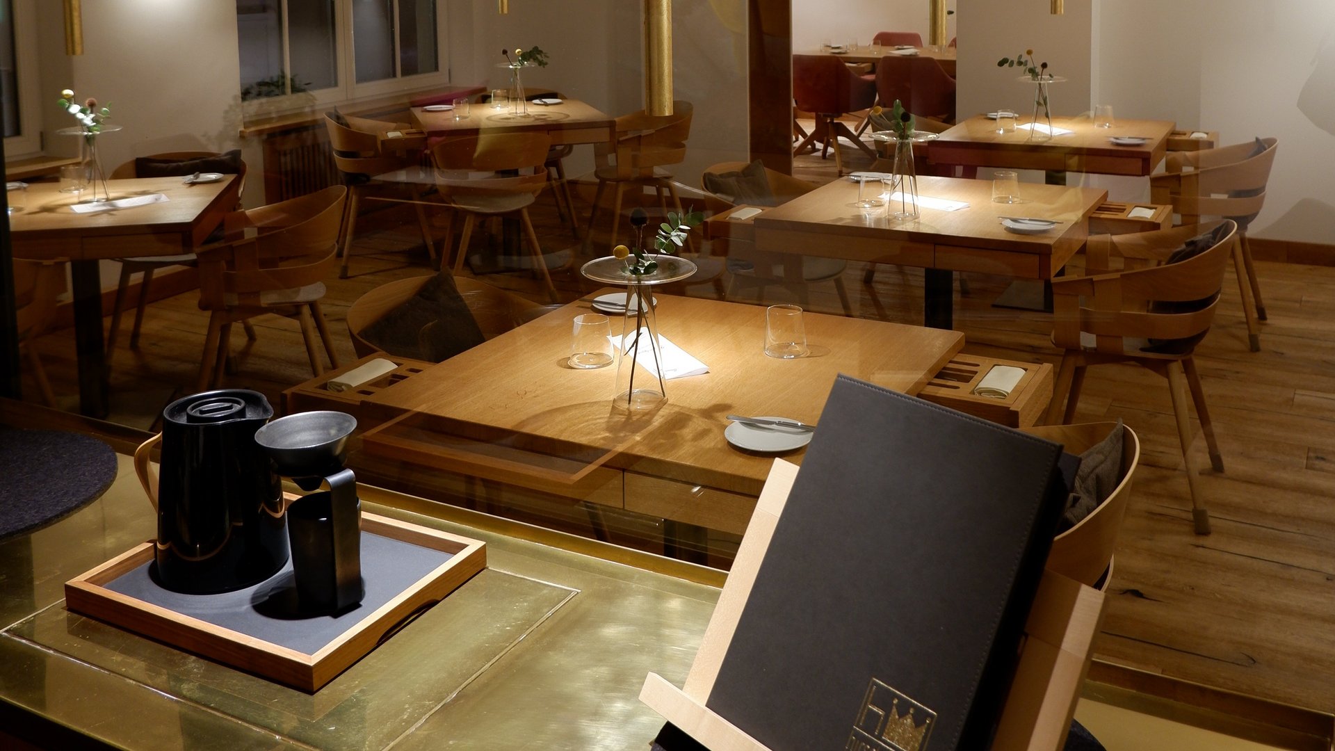 Restaurant in Parsberg: Enjoy gourmet Modern restaurant with wooden furniture and set tables under soft lighting