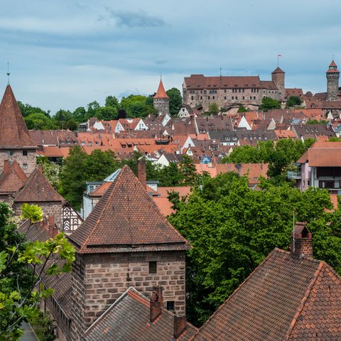Hotels in Regensburg and its surroundings: culturally rich! View of Nuremberg old town with castle and red tiled roofs under cloudy sky